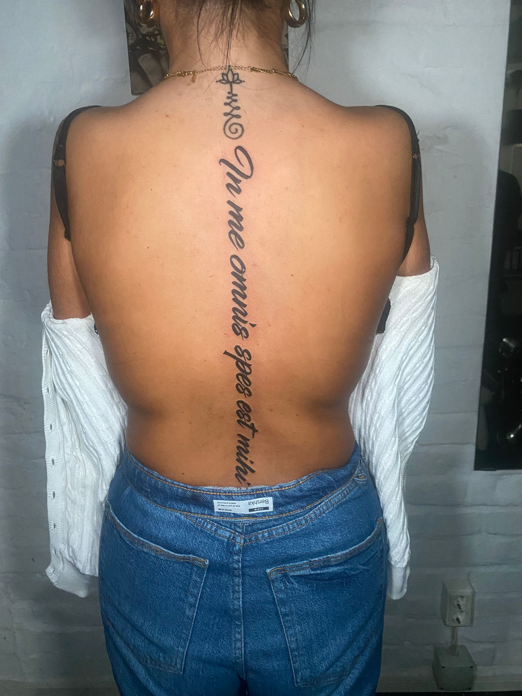 Fine line Latin script spine tattoo